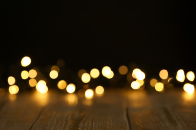 Photo of Wooden table and festive lights. Bokeh effect