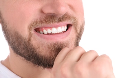 Photo of Young man with healthy teeth smiling on white background, closeup