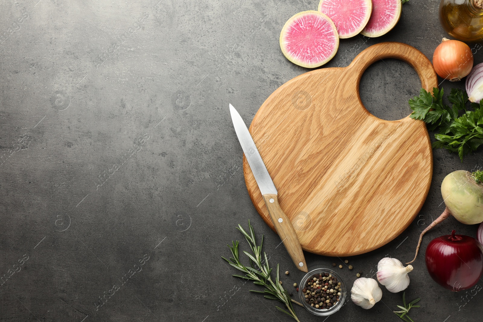 Photo of Flat lay composition with wooden cutting board and products on dark textured table. Space for text