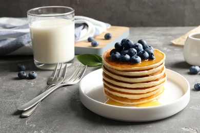 Photo of Plate with pancakes and berries on table