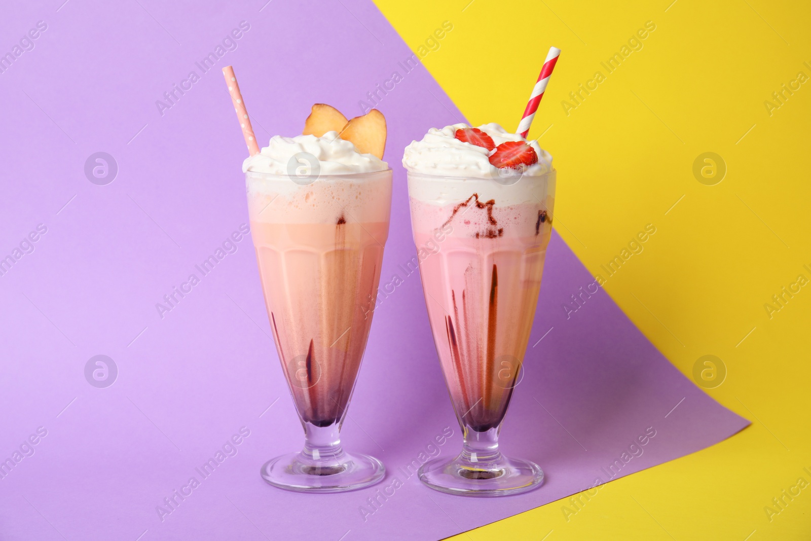 Photo of Glasses of tasty milk shakes on color background