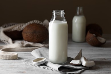 Coconut milk and nuts on white wooden table