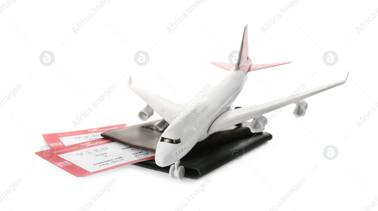 Photo of Toy airplane and passport with tickets on white background