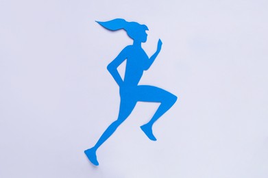 Photo of Woman`s health. Paper female figure running on white background, top view