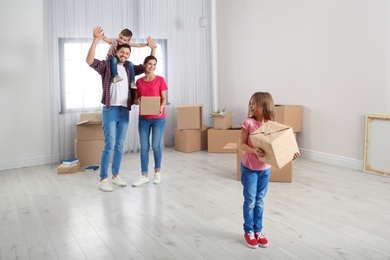 Photo of Happy family with moving boxes in their new house