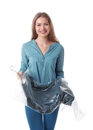 Young woman holding hanger with dress in plastic bag on white background. Dry-cleaning service