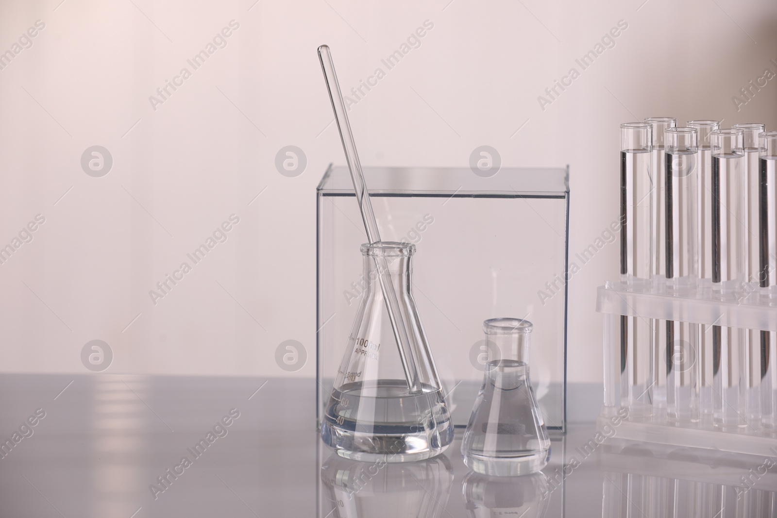 Photo of Laboratory analysis. Different glassware with liquid on white table against blurred background, space for text