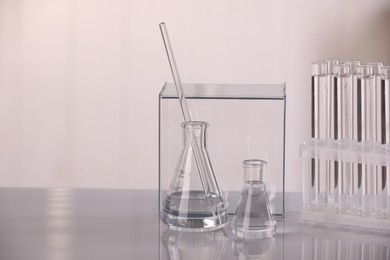 Laboratory analysis. Different glassware with liquid on white table against blurred background, space for text