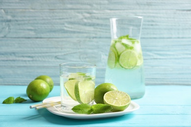 Photo of Natural lemonade with lime in glassware on wooden table