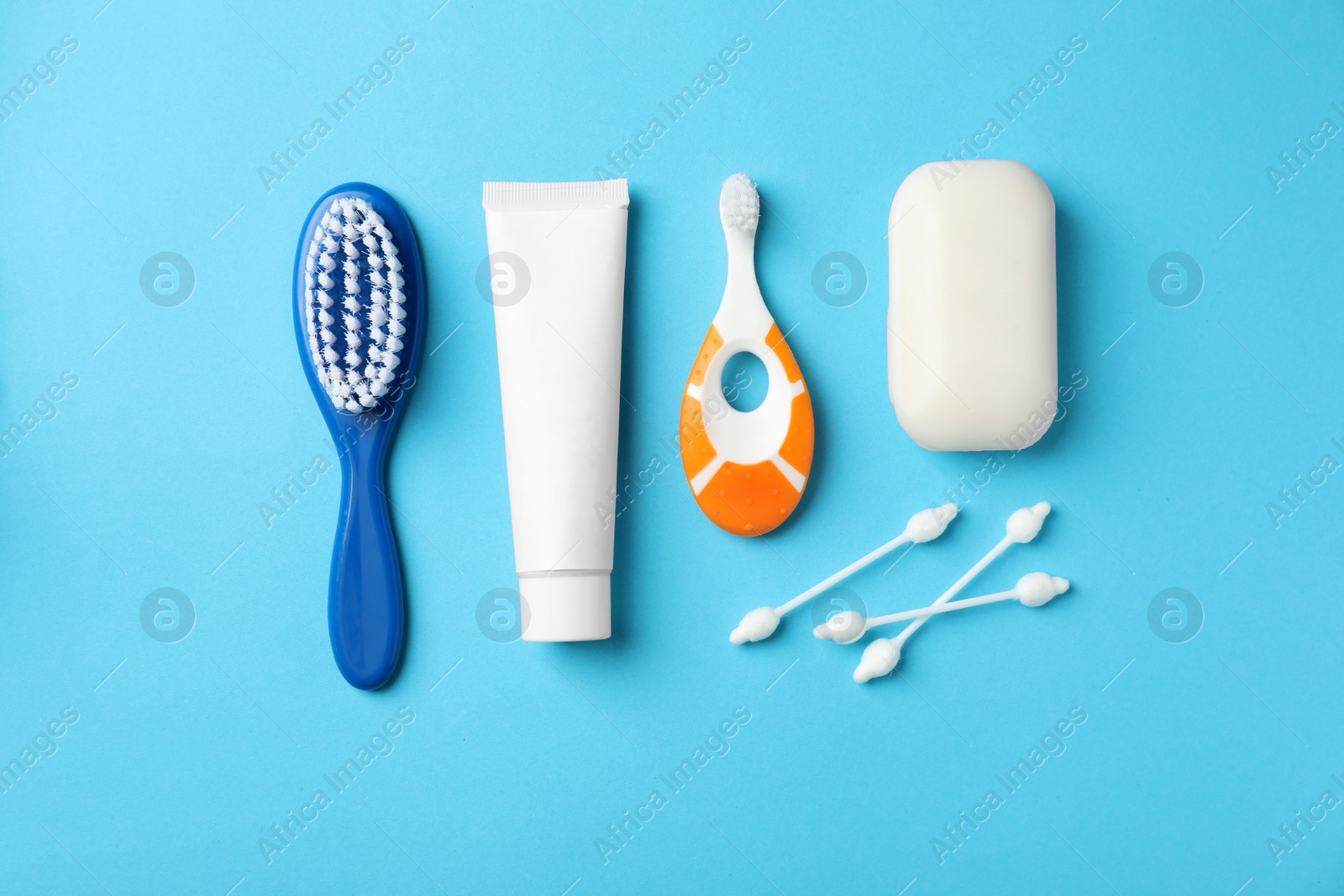 Photo of Flat lay composition with baby toothbrush and toiletries on color background