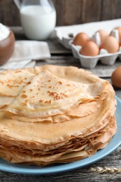 Photo of Stack of delicious crepes on wooden table, closeup