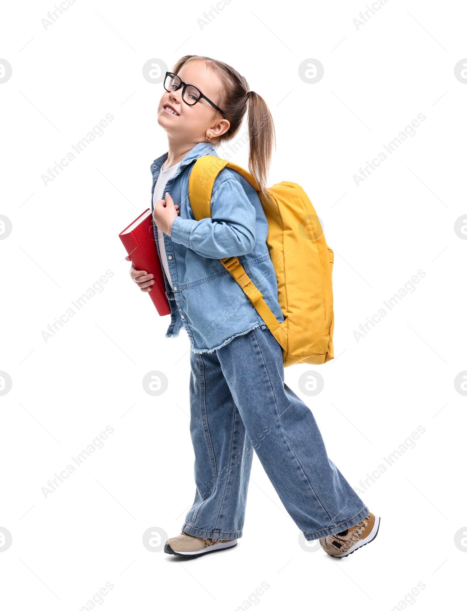 Photo of Cute little girl in glasses with book and backpack on white background