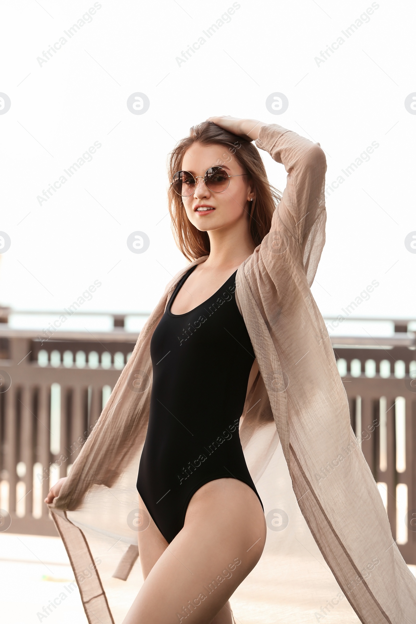 Photo of Beautiful young woman in swimsuit at resort