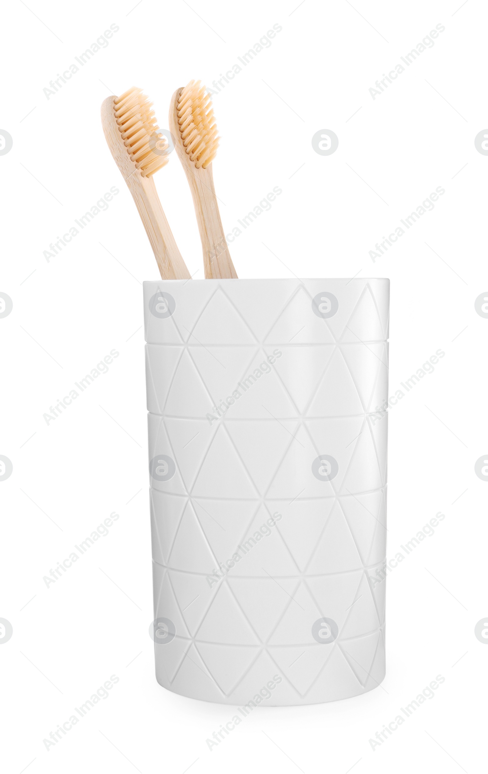 Photo of Bamboo toothbrushes in holder isolated on white