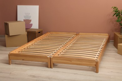 Photo of Wooden bed frame and cardboard boxes on floor in room