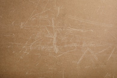 Photo of Old fiberboard with scratches as background, closeup