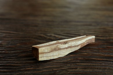 Palo santo stick on wooden table, closeup