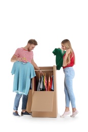 Young couple near wardrobe boxes on white background