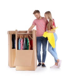 Young couple near wardrobe boxes on white background