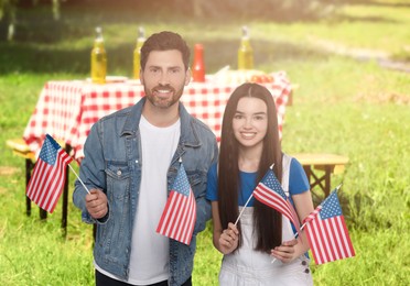 Image of 4th of July - Independence day of America. Happy father and daughter with national flags of United States having picnic in park