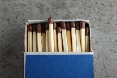Photo of Open box with matches on grey background, closeup