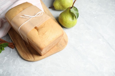 Tasty tied pear bread on light grey table, space for text. Homemade cake