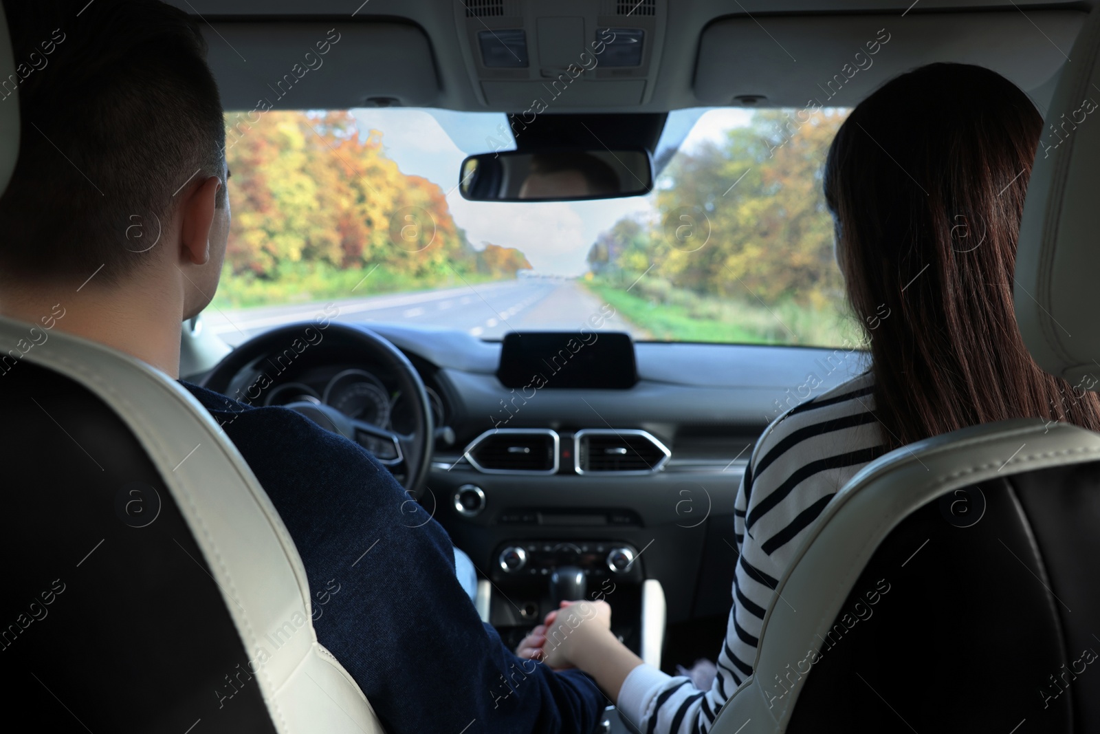 Photo of Happy young couple travelling together by car