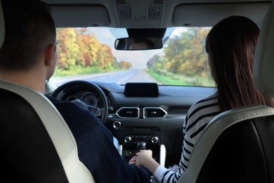 Happy young couple travelling together by car