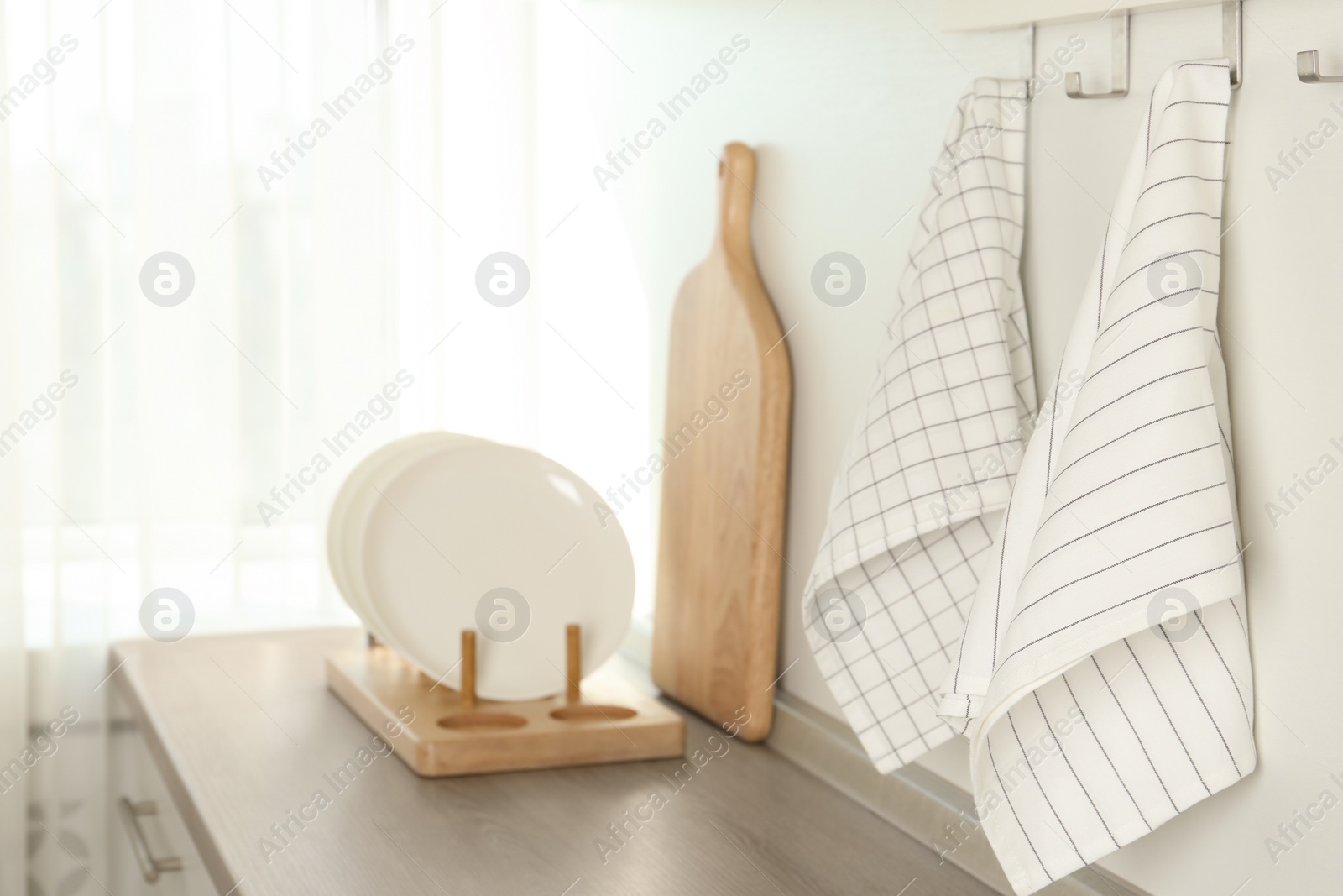 Photo of Different kitchen towels hanging on hook rack indoors