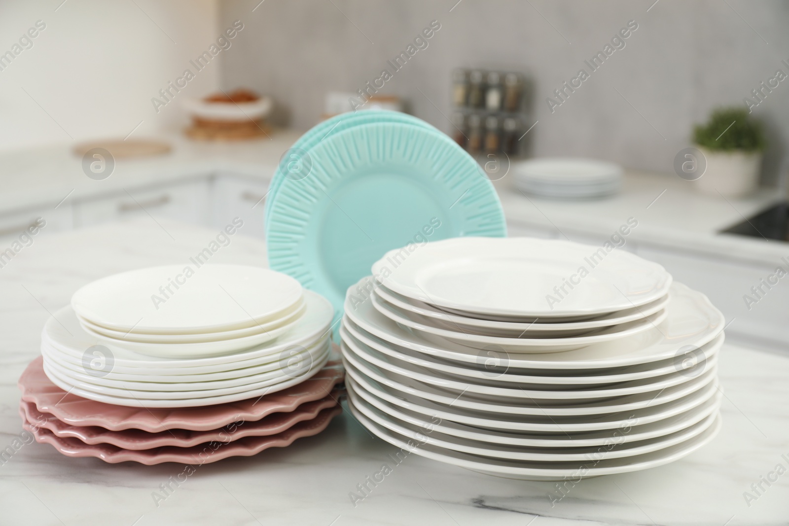 Photo of Clean plates on white marble table in kitchen