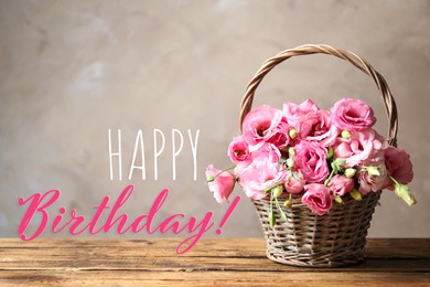 Image of Happy Birthday! Beautiful pink Eustoma flowers in wicker basket on wooden table  