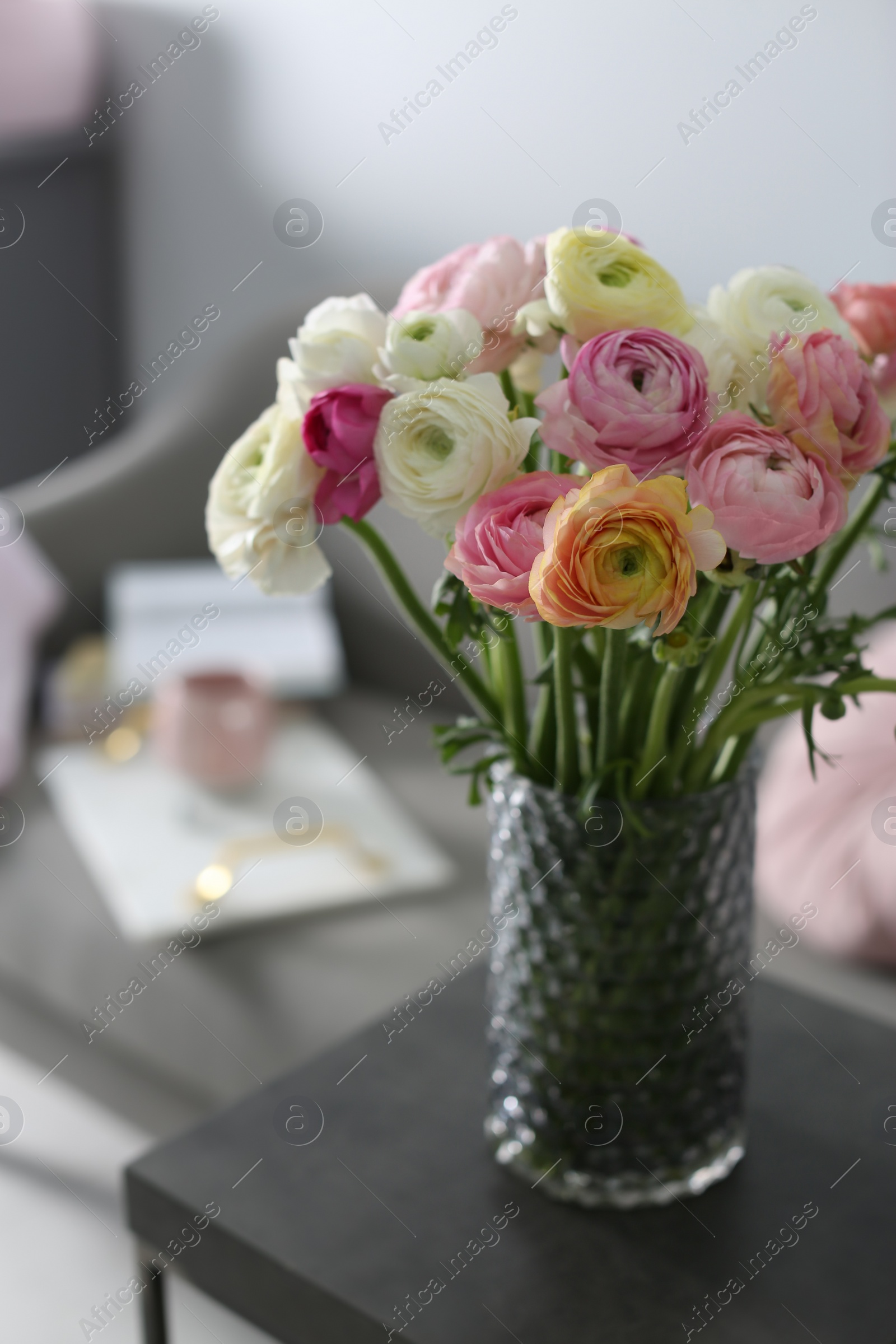 Photo of Bouquet of beautiful ranunculuses on table in living room