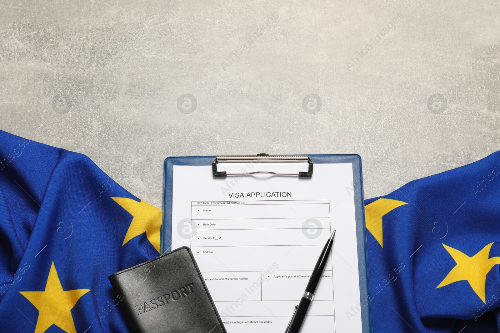 Photo of Visa application form, passport, pen and flag of European Union on light grey table flat lay. Space for text