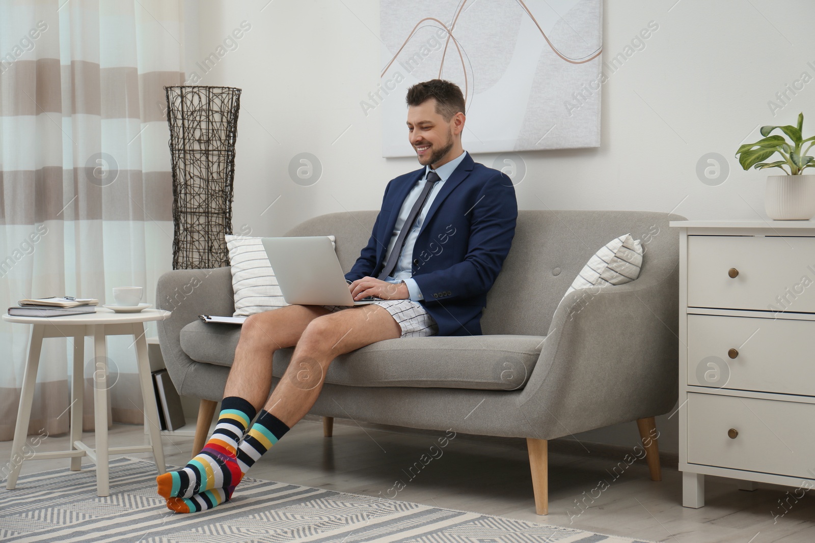 Photo of Businessman wearing shirt and underwear during video call at home