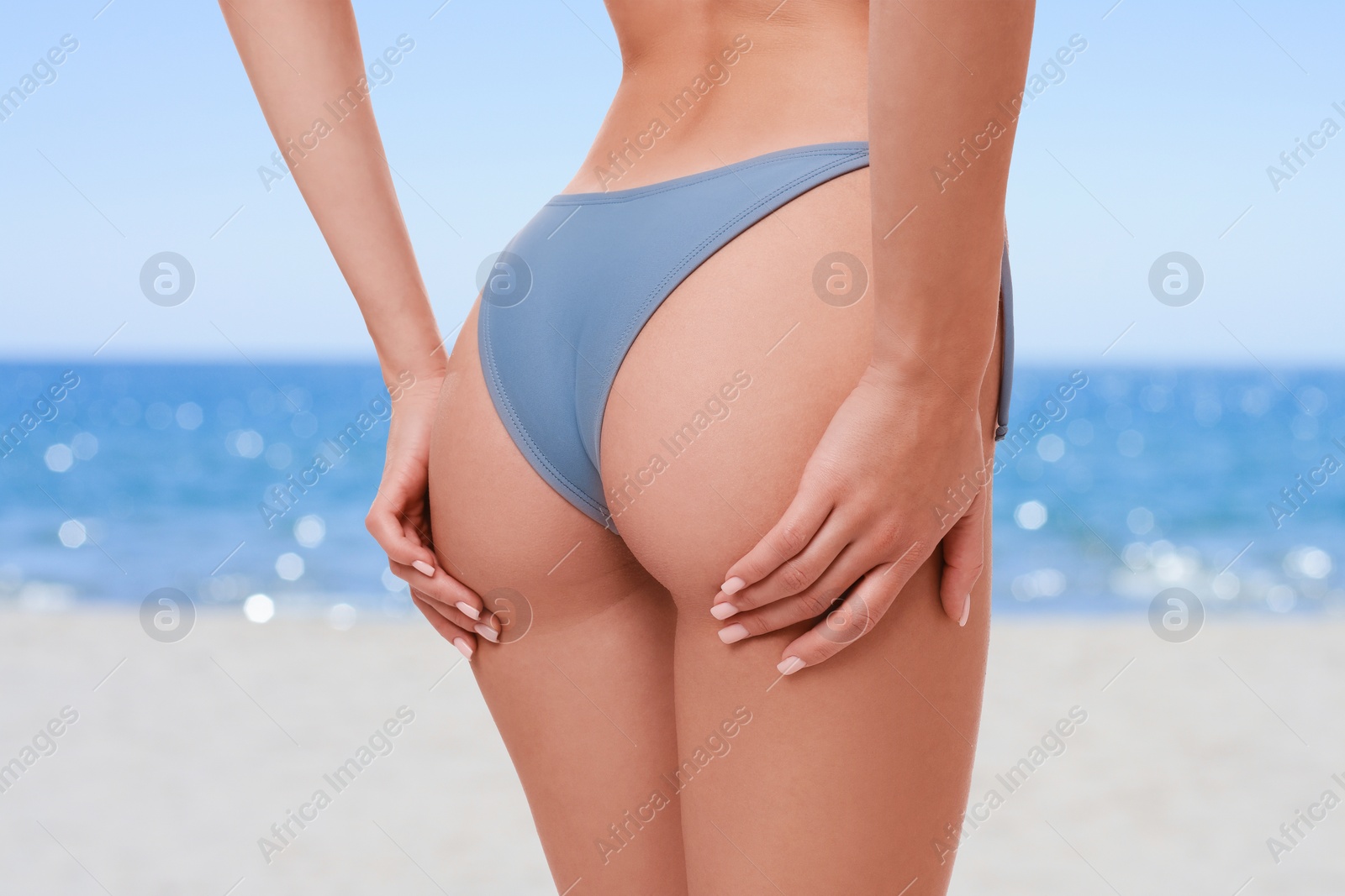 Image of Woman in stylish bikini on sandy beach near sea, closeup