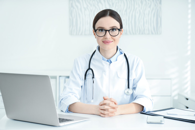 Photo of Portrait of young female doctor in white coat at workplace