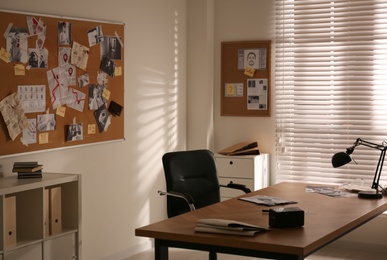 Photo of Detective workplace and evidence board in modern office