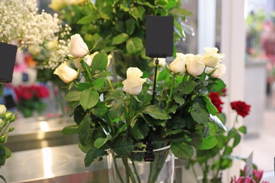 Photo of Beautiful fresh flowers in shop. Florist's workplace