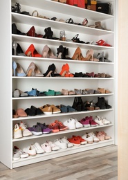 Photo of Shelving unit with different shoes. Element of dressing room interior