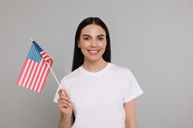 Photo of 4th of July - Independence Day of USA. Happy woman with American flag on light grey background