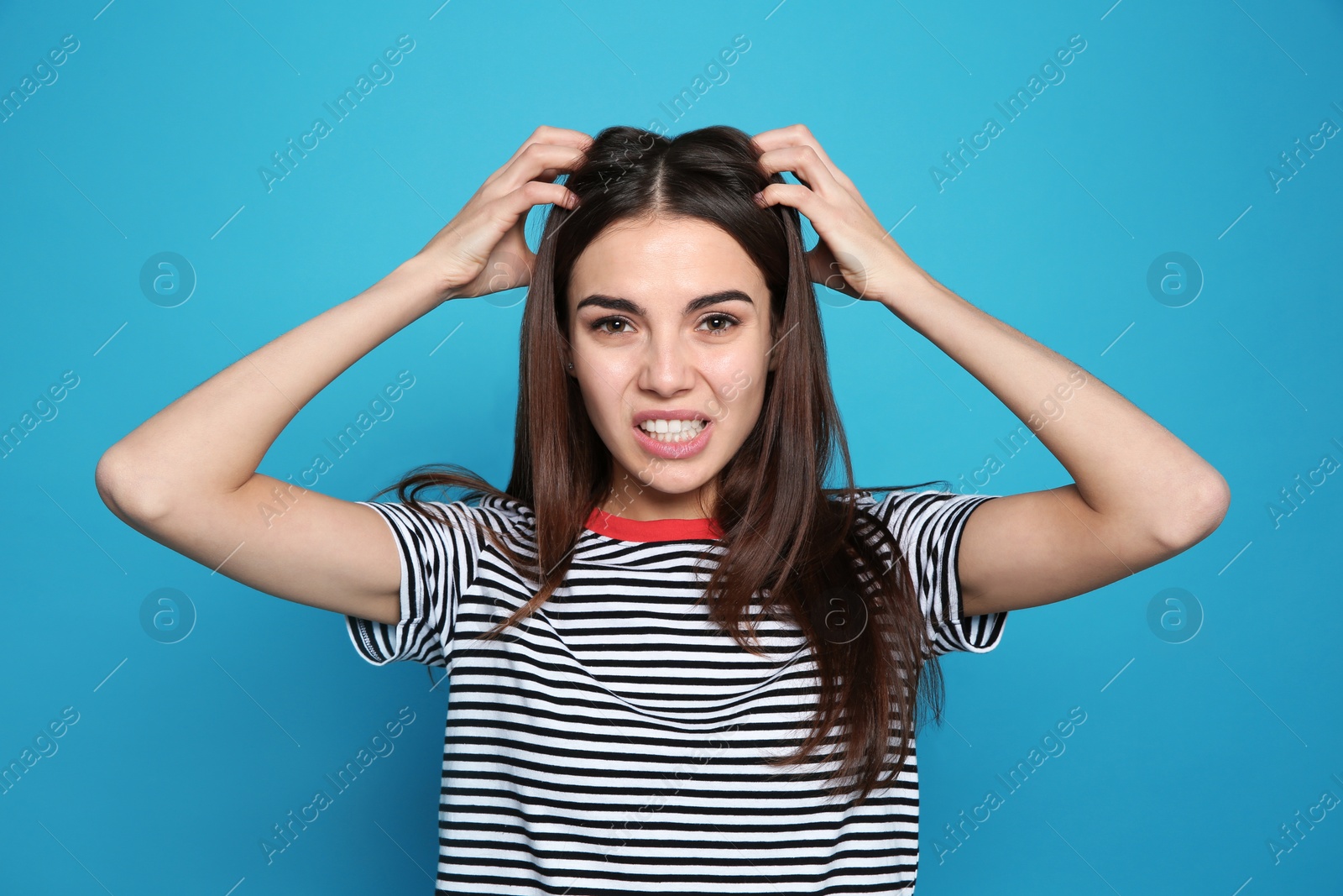 Photo of Young woman scratching head on color background. Annoying itch