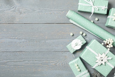 Photo of Christmas gift boxes on grey wooden background, flat lay. Space for text