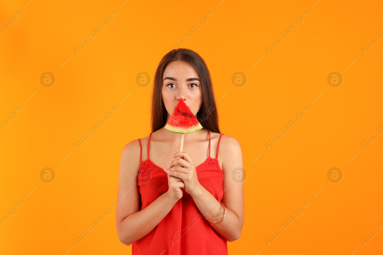 Photo of Beautiful young woman posing with watermelon on color background