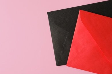 Colorful paper envelopes on pink background, top view. Space for text