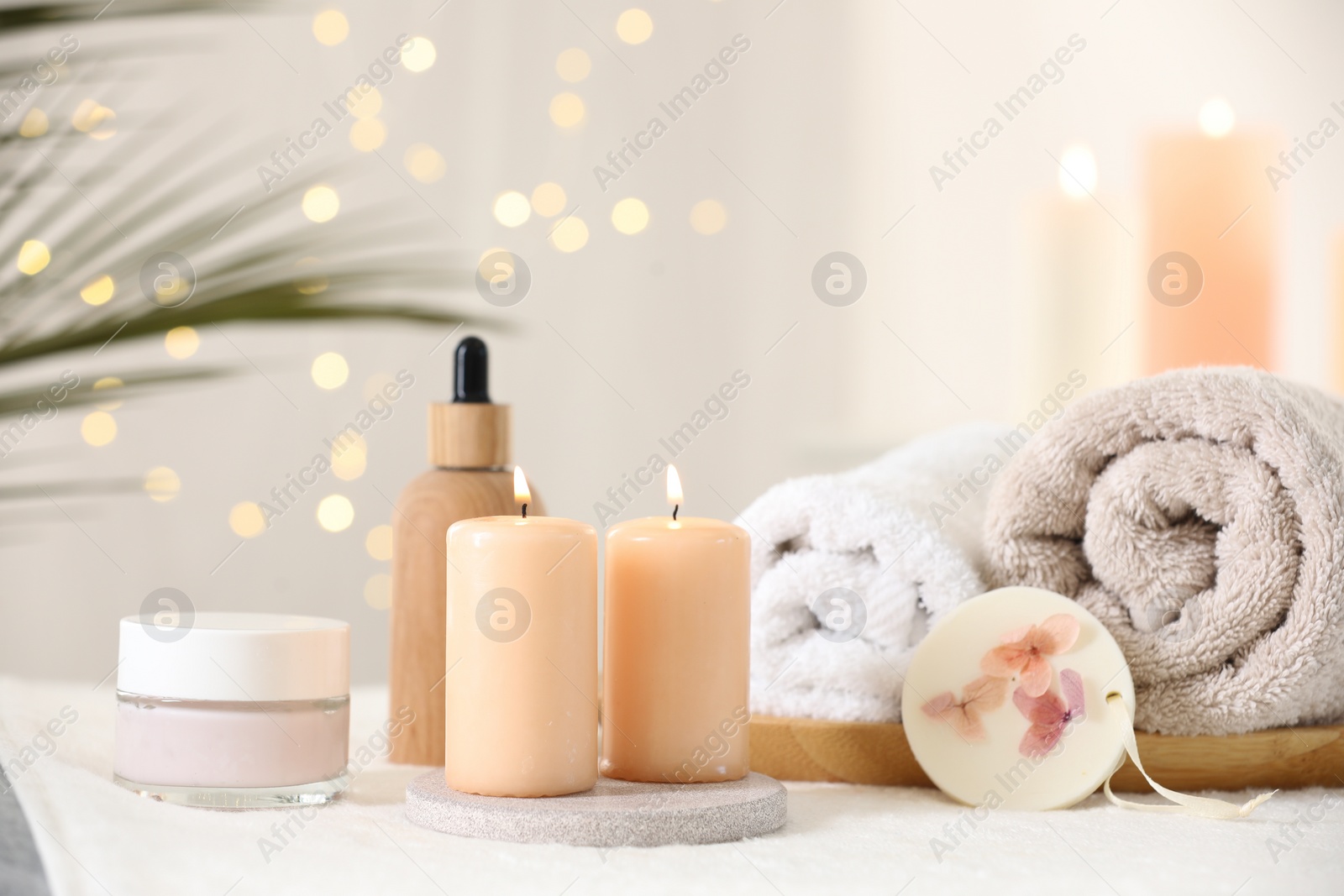 Photo of Spa composition. Burning candles and personal care products on soft surface