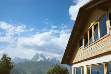 Photo of Beautiful wooden cottage near mountains on sunny day