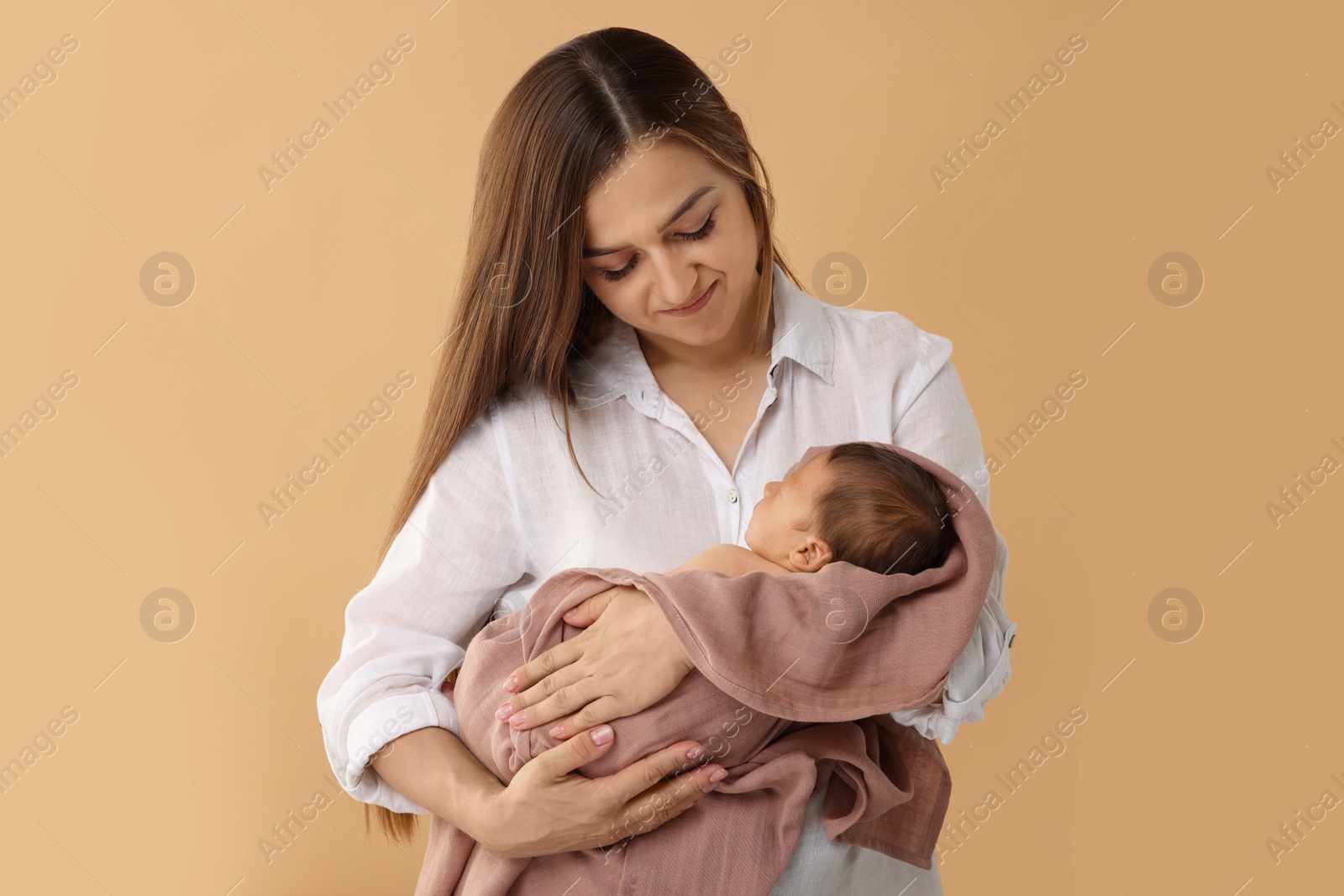 Photo of Mother with her cute newborn baby on beige background