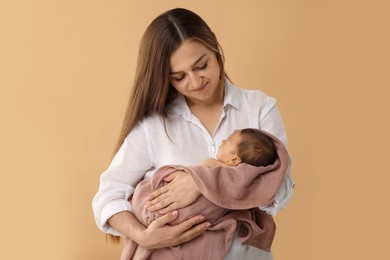 Photo of Mother with her cute newborn baby on beige background