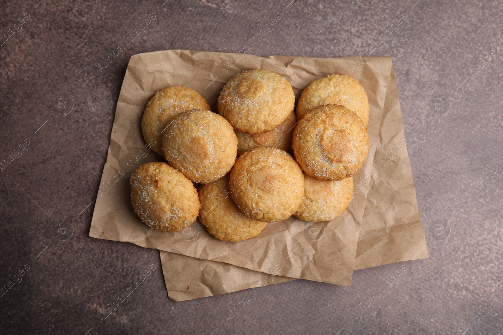 Photo of Tasty sweet sugar cookies on brown table, top view