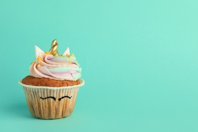 Photo of Cute sweet unicorn cupcake on turquoise background, space for text